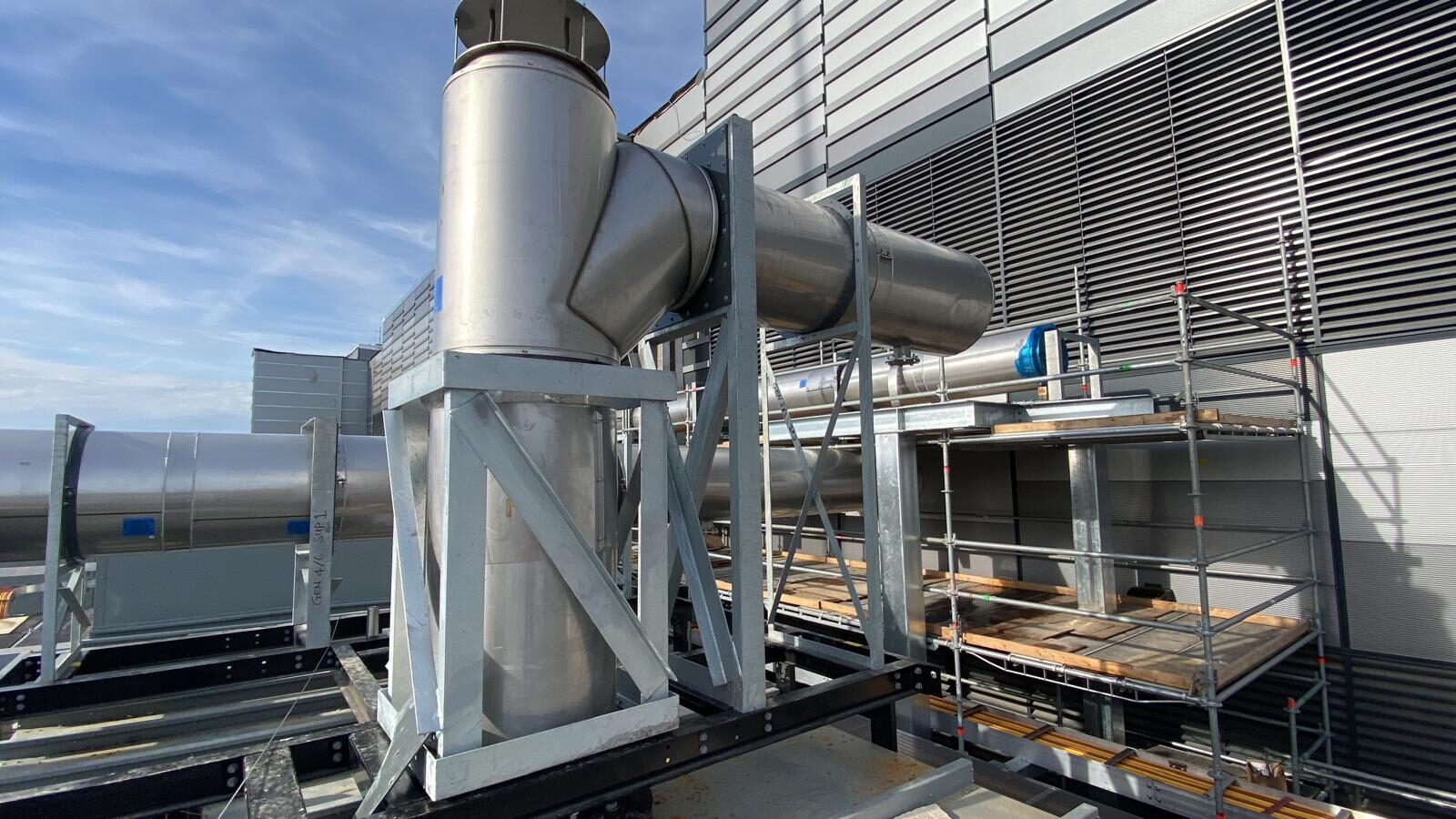 Stainless exhaust stack and round duct on a commercial rooftop